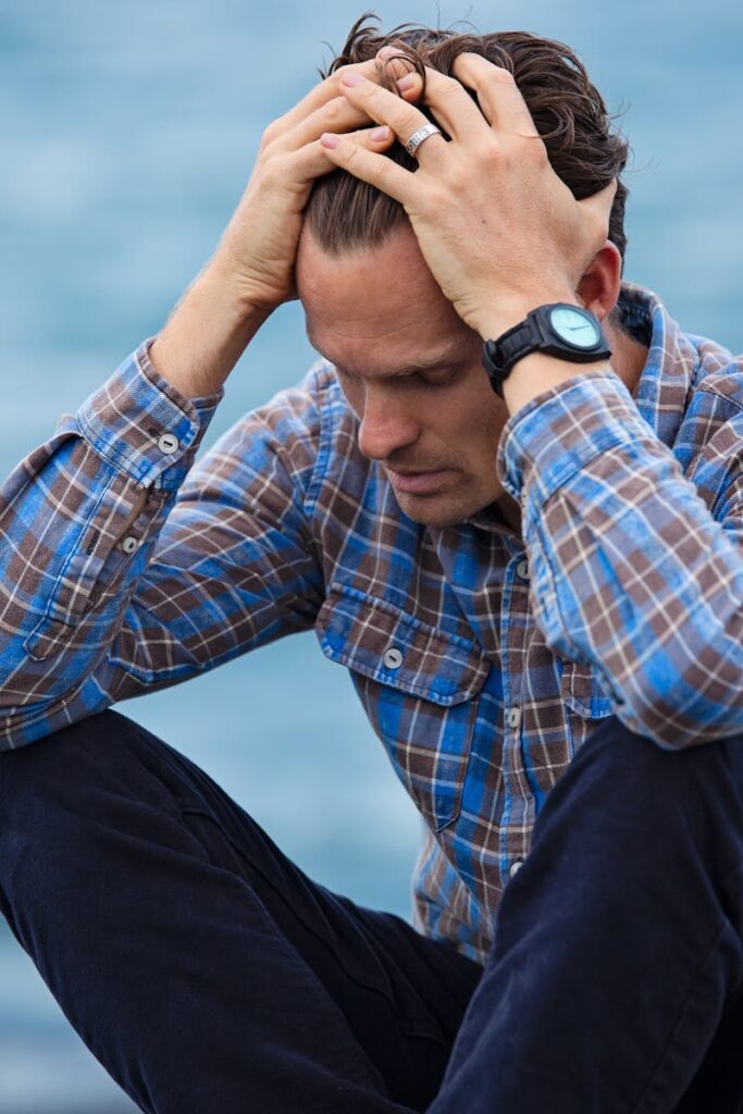 Man in Blue and Brown Plaid Dress Shirt Touching His Hair